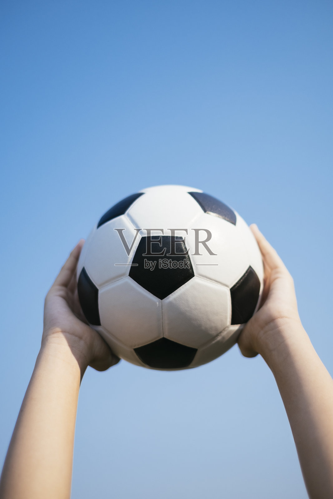 低角度视图下手握球与蓝天相对照片摄影图片