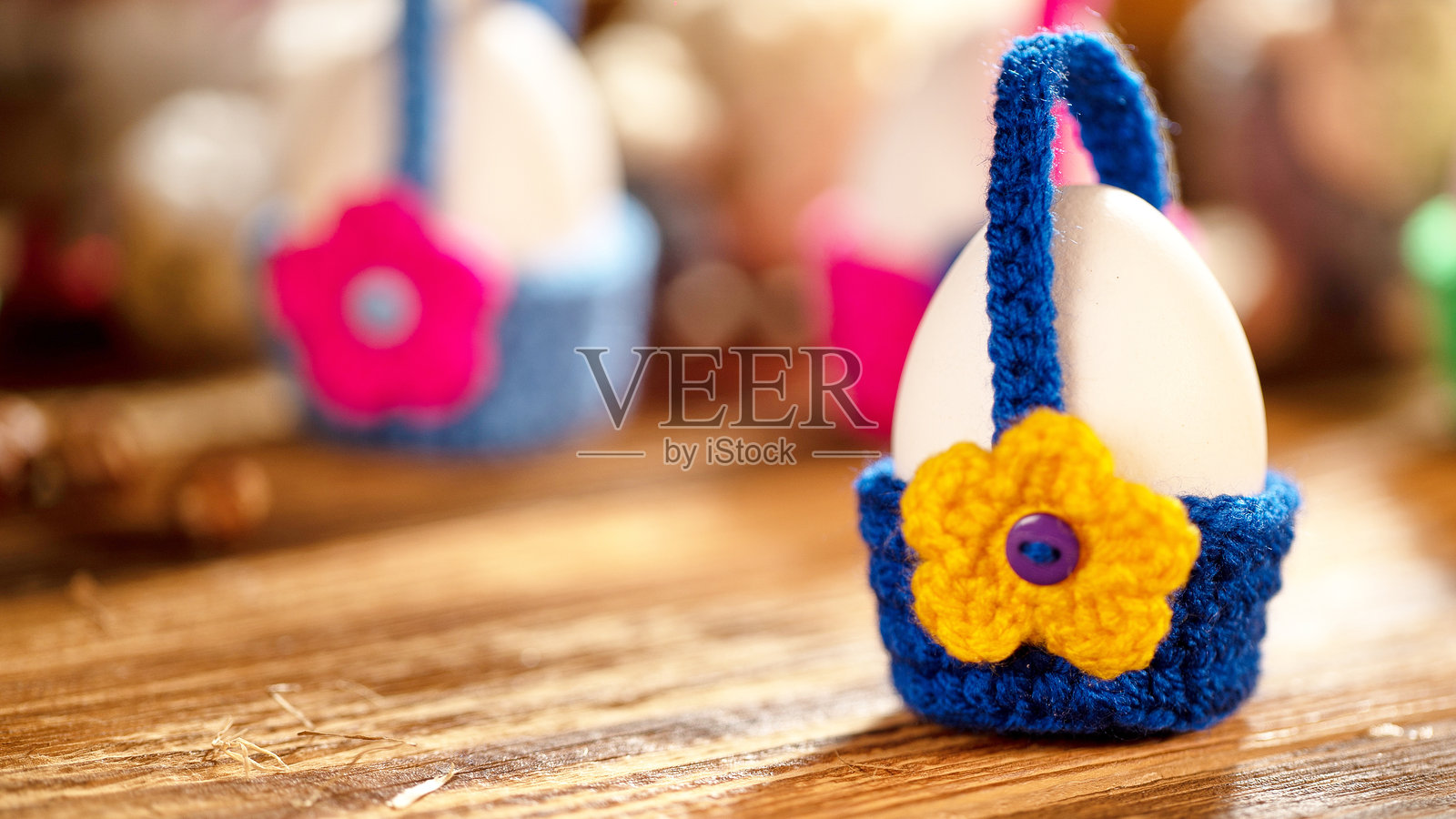 蓝色钩针篮中的鸡蛋,装饰有黄色花朵照片摄影图片