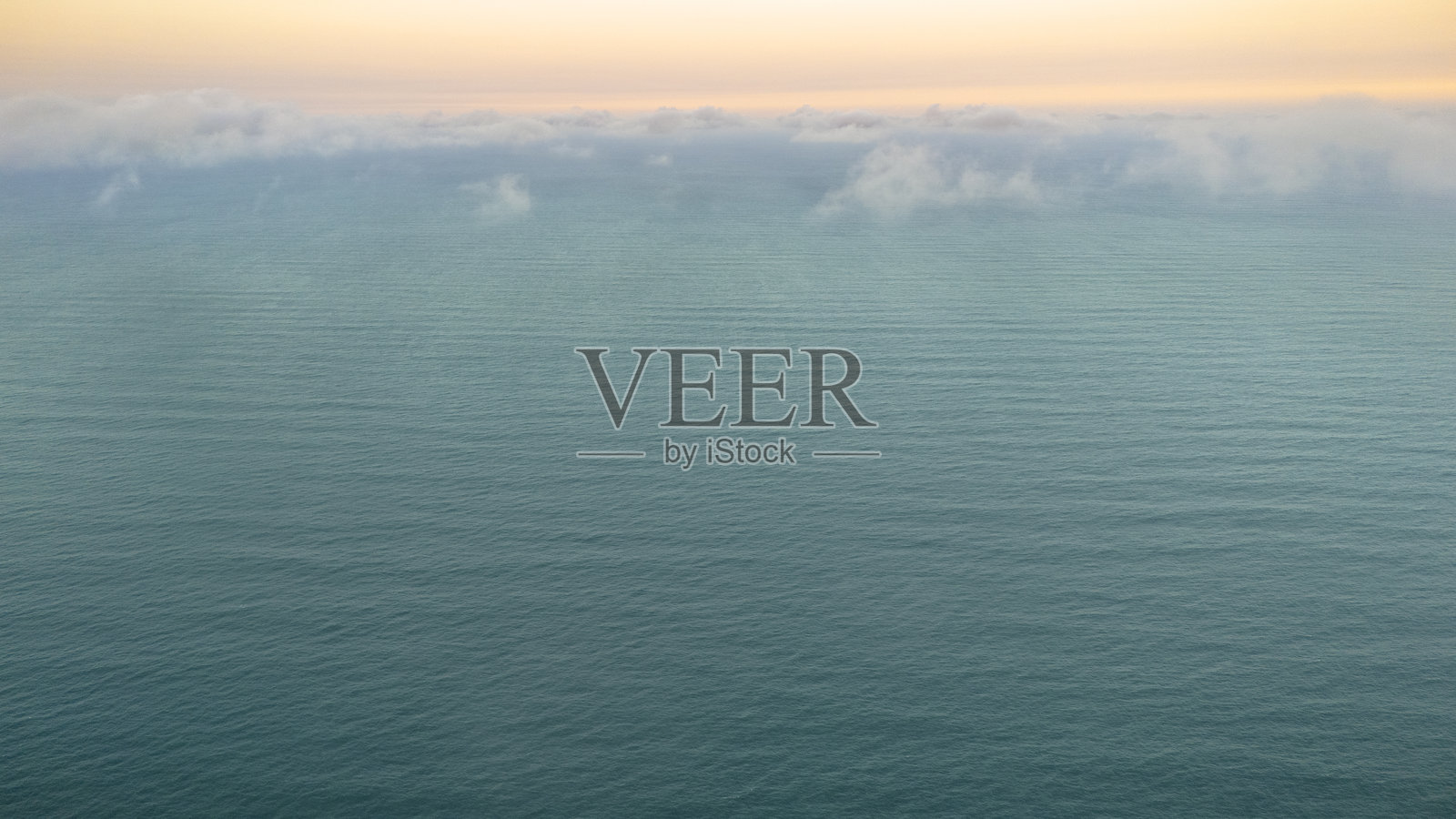 美丽的墨西哥湾海洋鸟瞰图。它的碧绿色在远处一群白云中消失于地平线。照片摄影图片