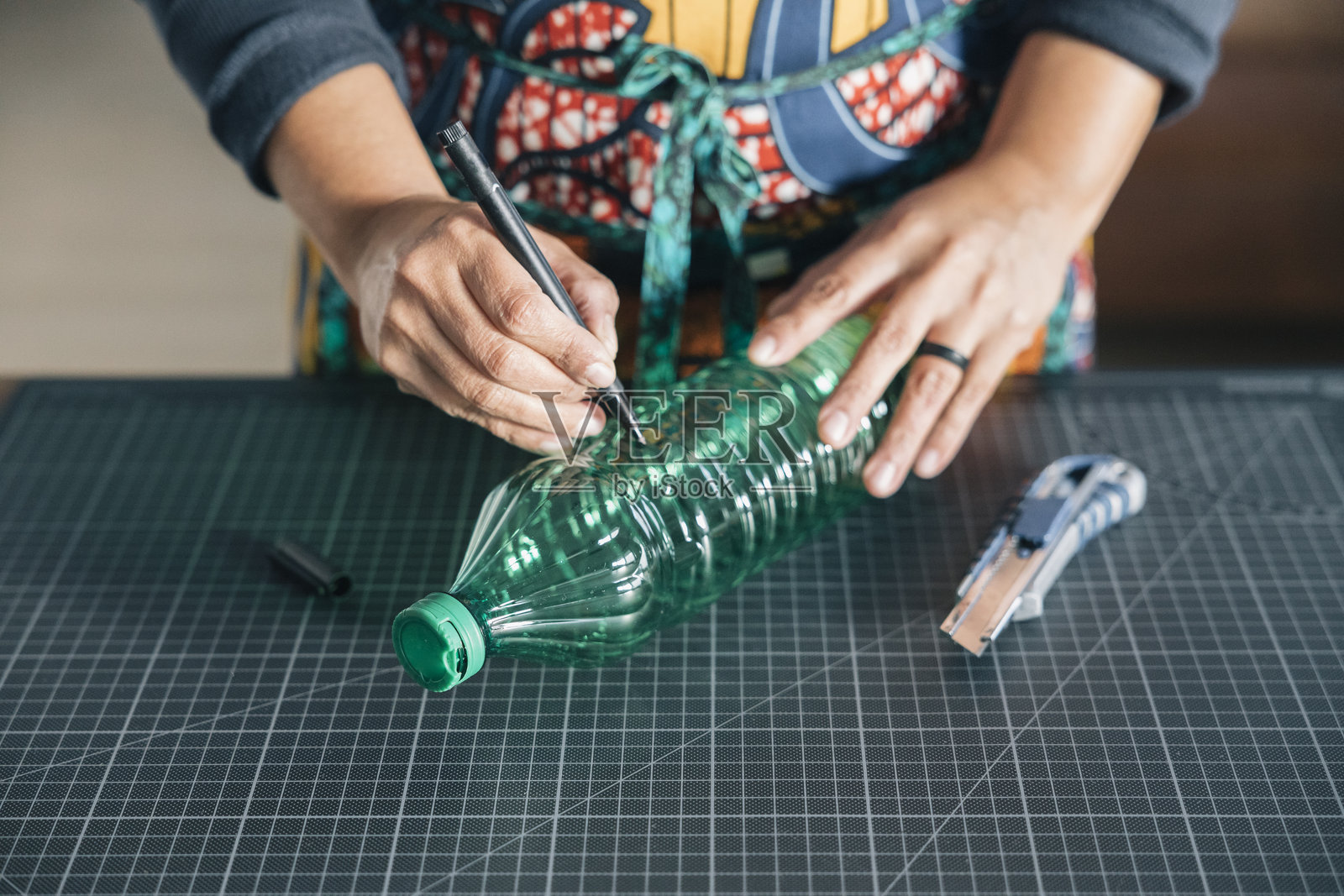 工匠在塑料瓶上标记以便切割和回收照片摄影图片