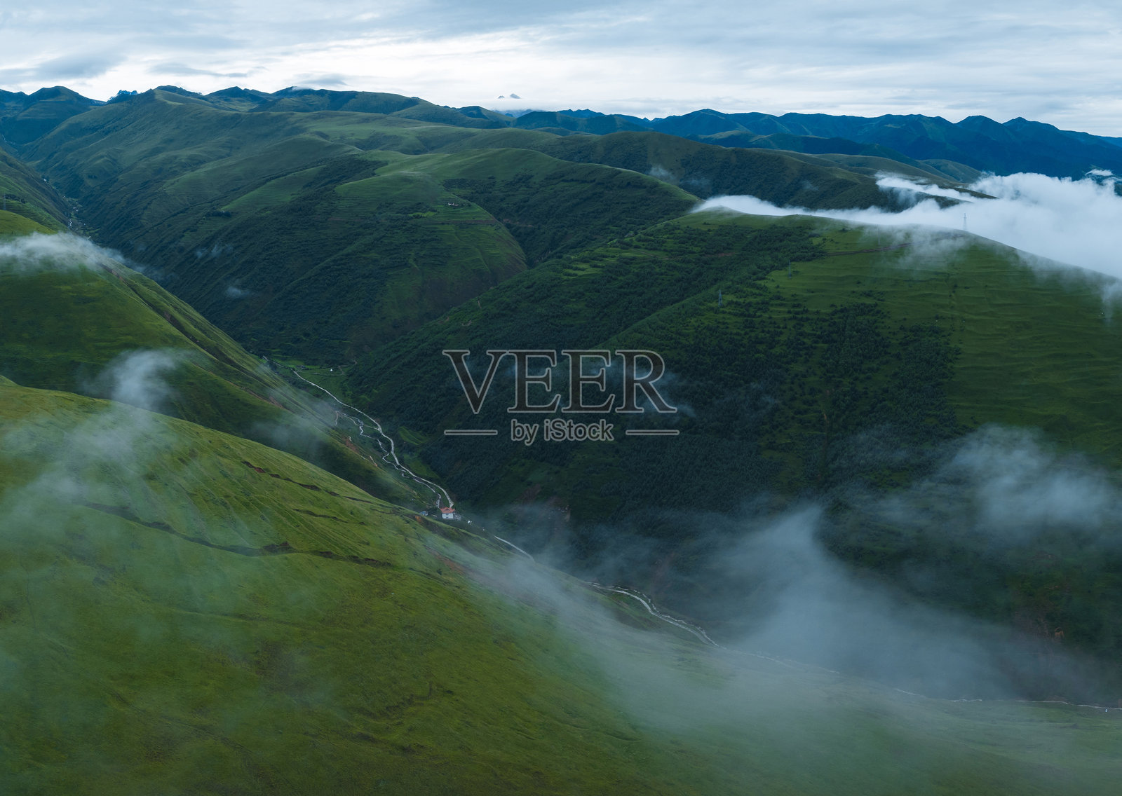 美丽草原山顶的风景,山谷中升起的雾气照片摄影图片