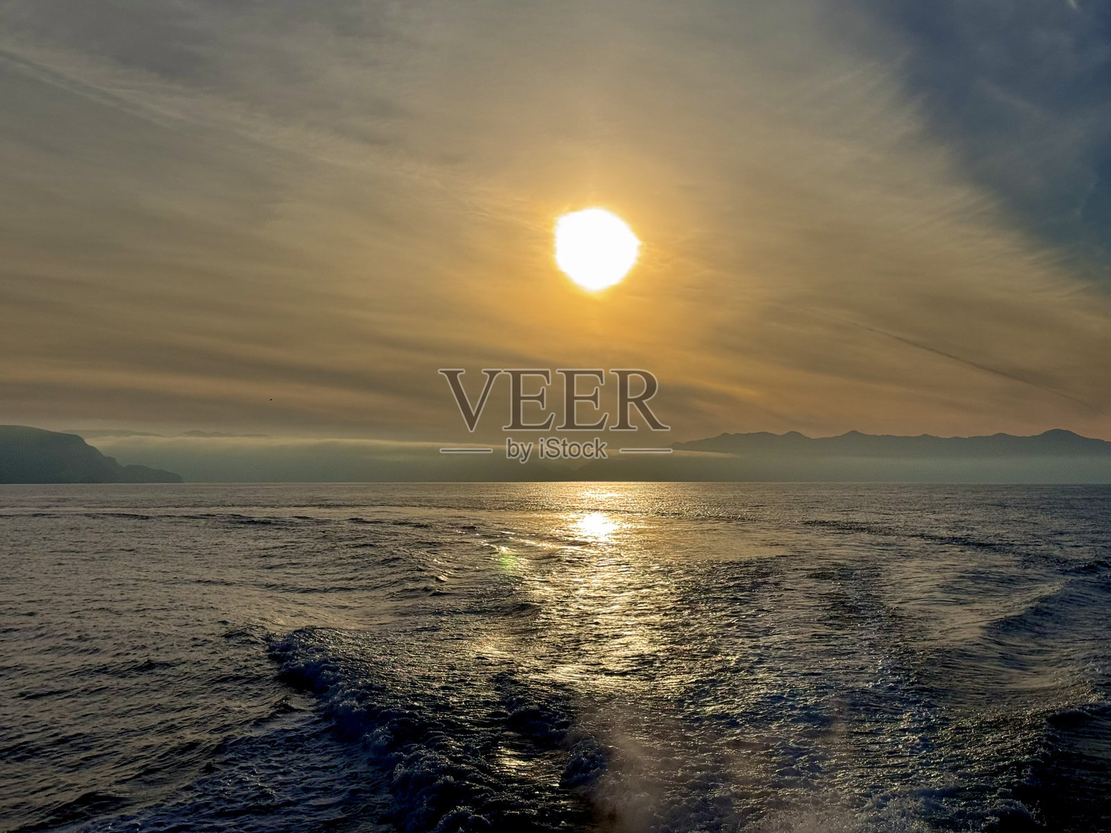 加州海峡群岛后方的船只与太平洋上黄灰色的日落照片摄影图片