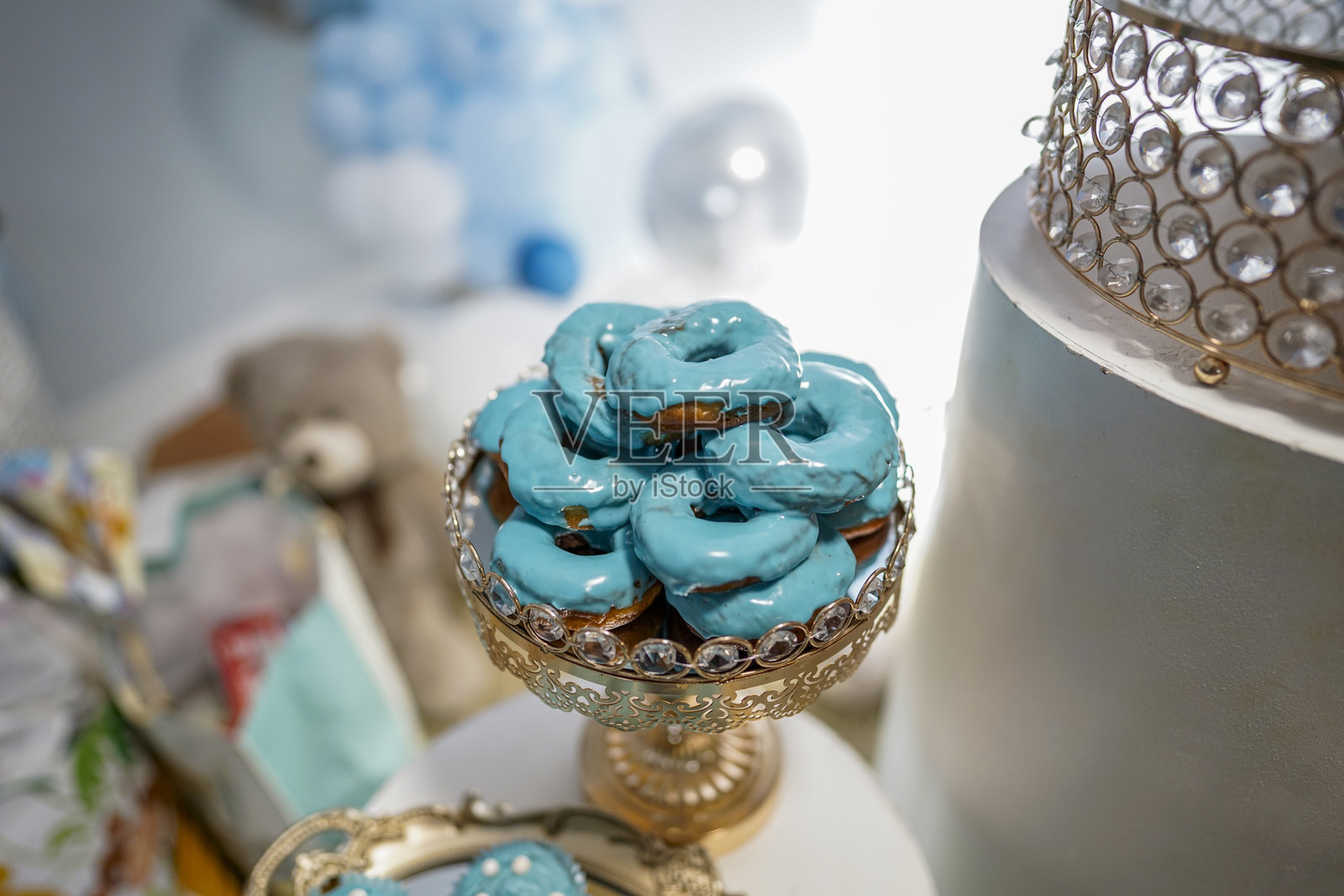 浸泡在浅蓝色奶油中的甜甜圈,婴儿洗礼派对的礼物照片摄影图片