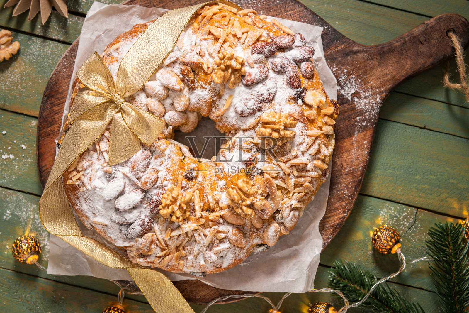 波洛女王蛋糕,一种庆祝用的环形蛋糕,上面装饰着杏仁、坚果、干果和葡萄干,并撒上糖粉,非常适合圣诞节和新年等节日场合。俯视图照片摄影图片