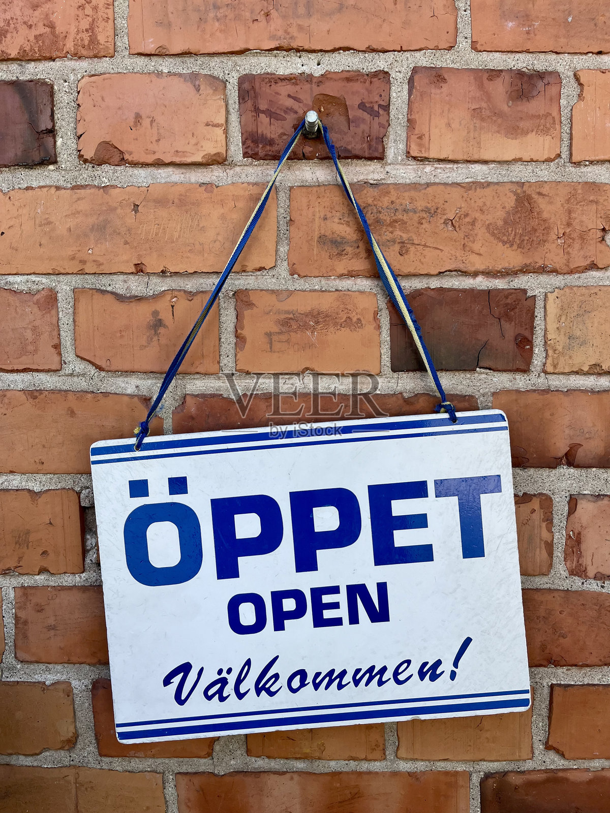在石墙前的瑞典语“开放”标志照片摄影图片