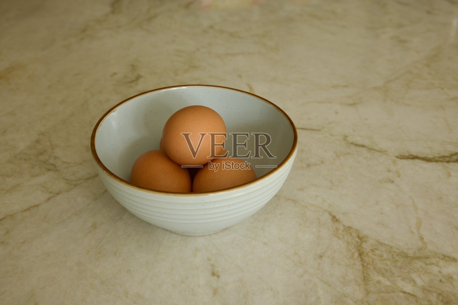 新鲜的棕色鸡蛋放在陶瓷碗里照片摄影图片