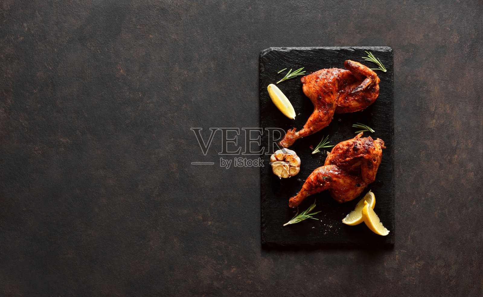 黑色背景上的烤半只鸡,留有空白空间照片摄影图片