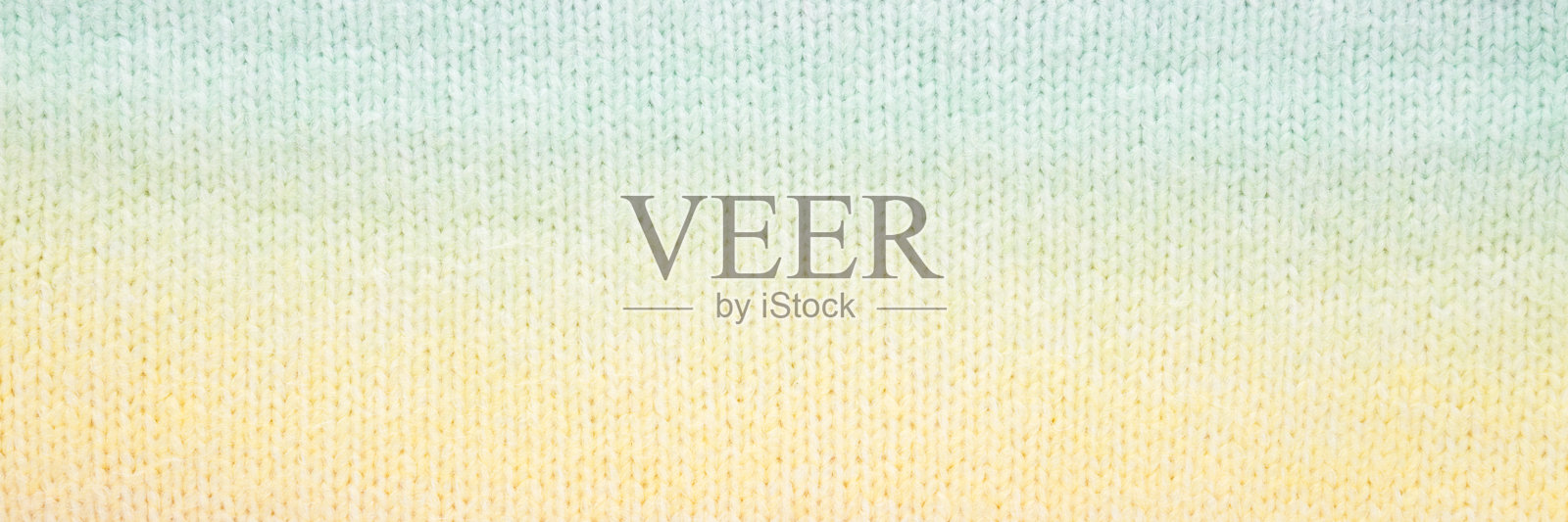 浅黄色绿色柔软针织面料图案背景。特写。宽幅横幅。俯视图。照片摄影图片