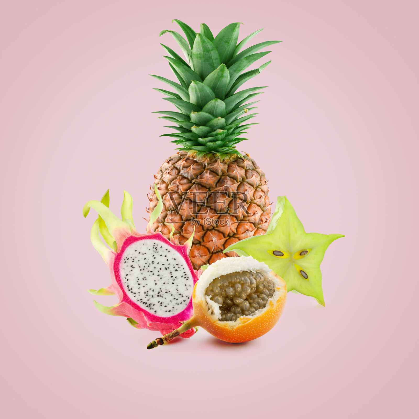 浅粉色背景上的异域水果照片摄影图片