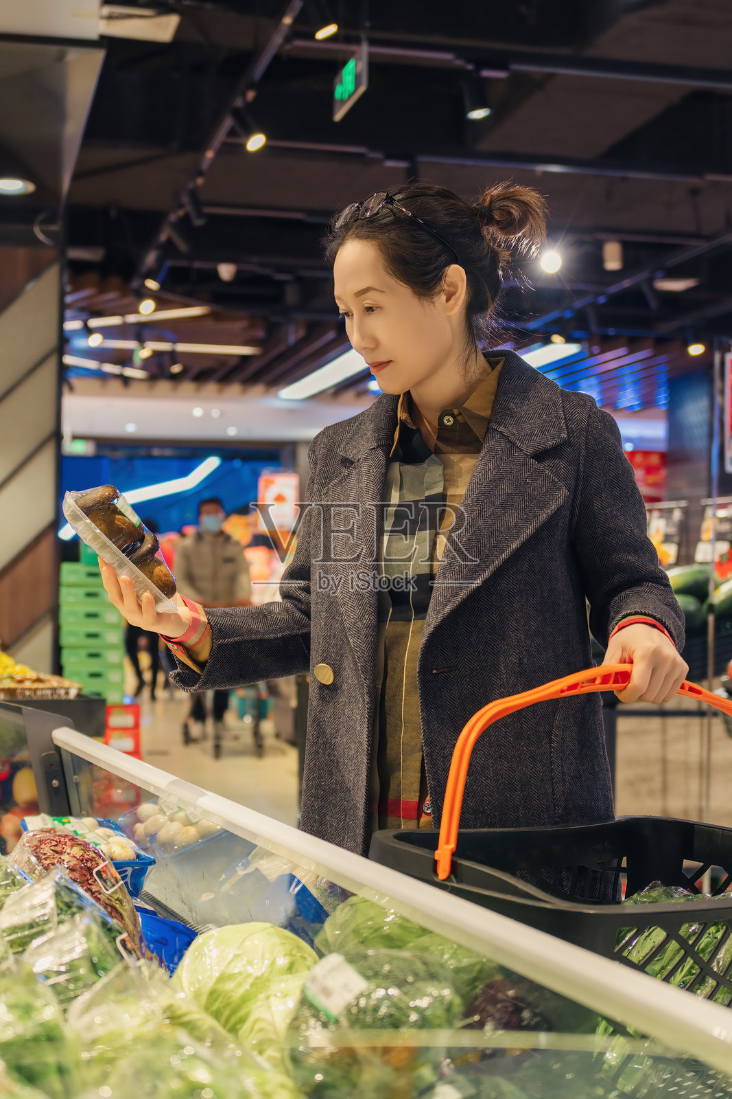 女性在现代超市购物,挑选新鲜蔬菜和杂货照片摄影图片