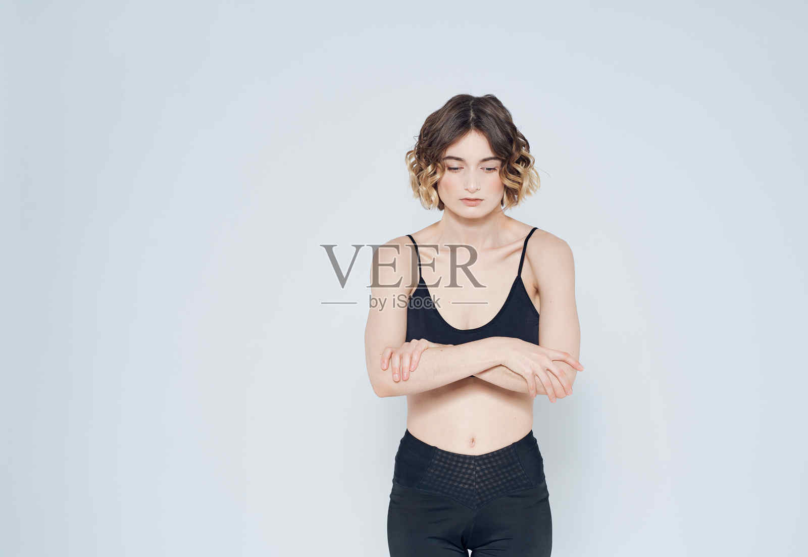 女子体操运动员在浅色背景下锻炼照片摄影图片