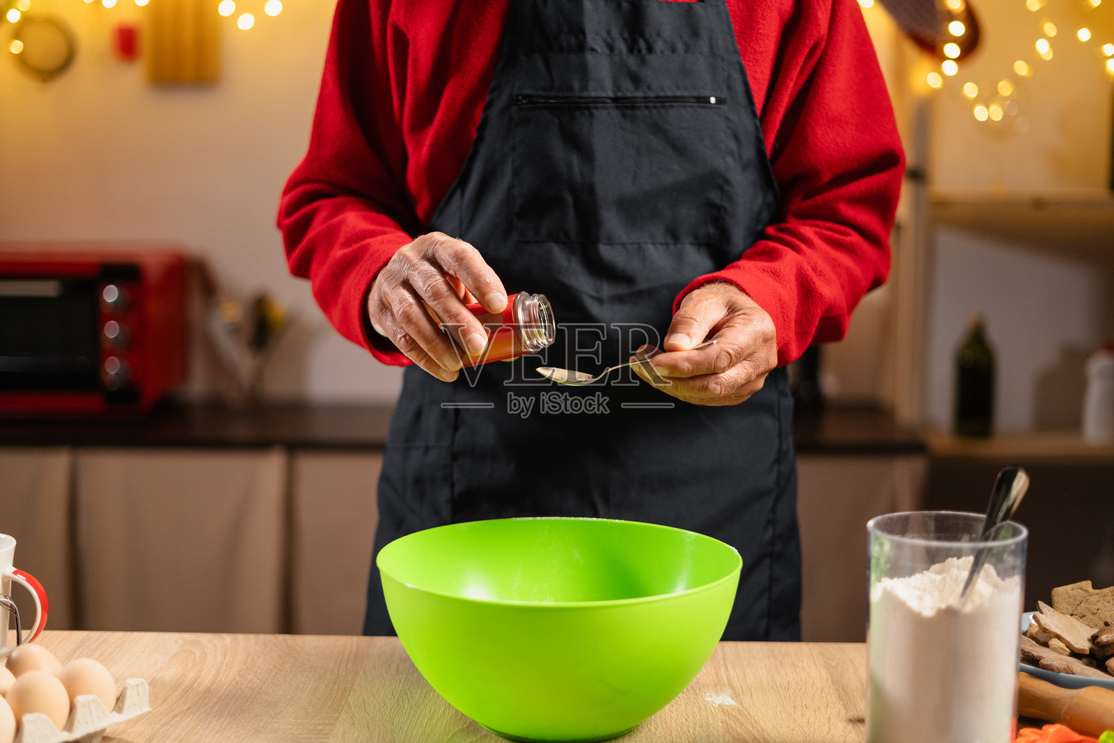 老年人在准备姜饼饼干面团,加入圣诞香料照片摄影图片