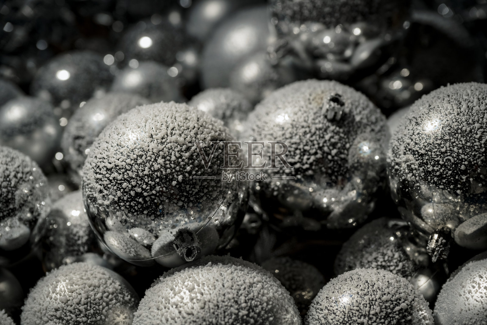 圣诞银色球饰上飘落的雪花,背景中闪烁着金色灯光照片摄影图片