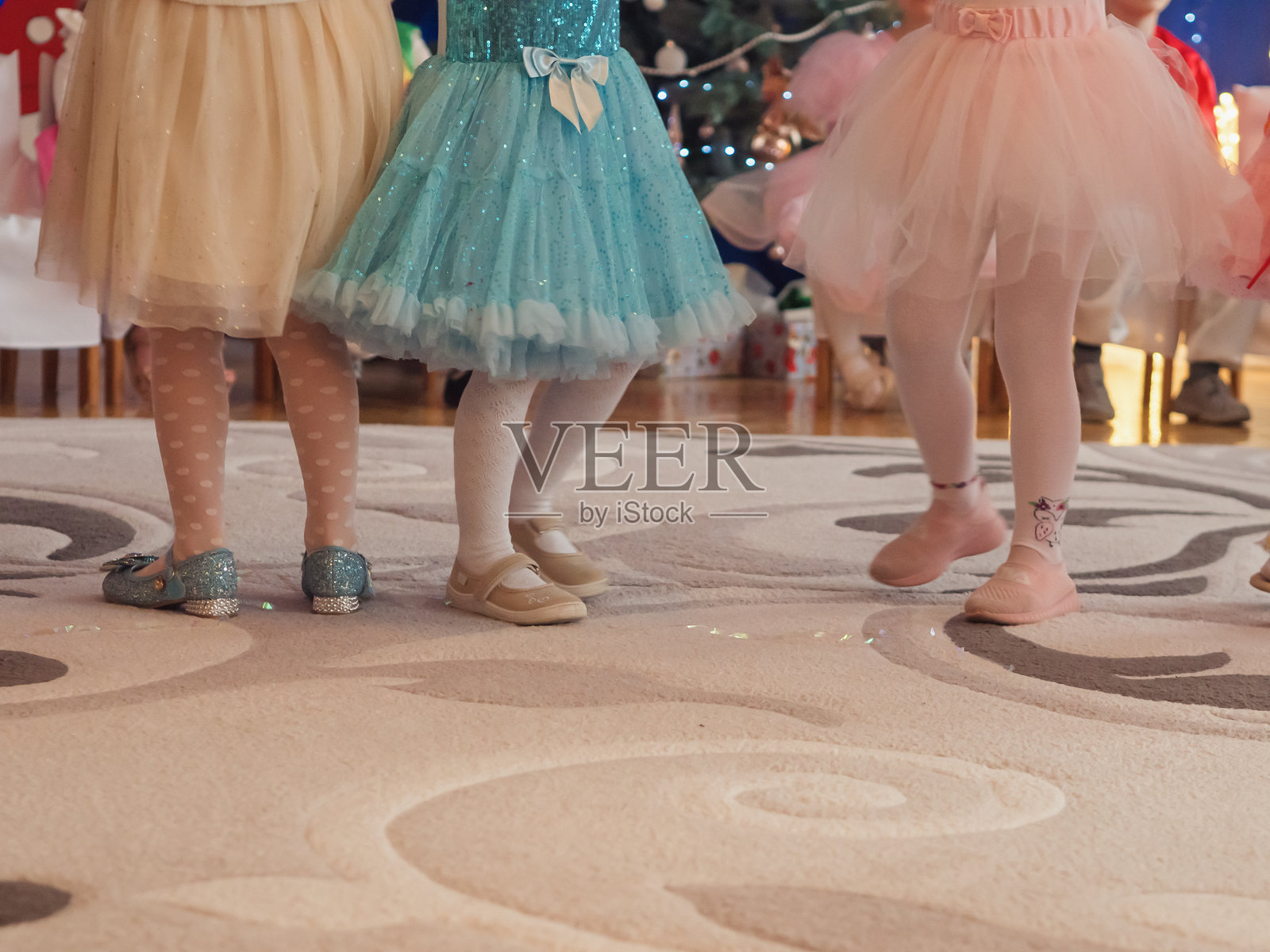 幼儿园冬季音乐会上穿着仙女裙的小女孩们的腰部以下视角照片摄影图片