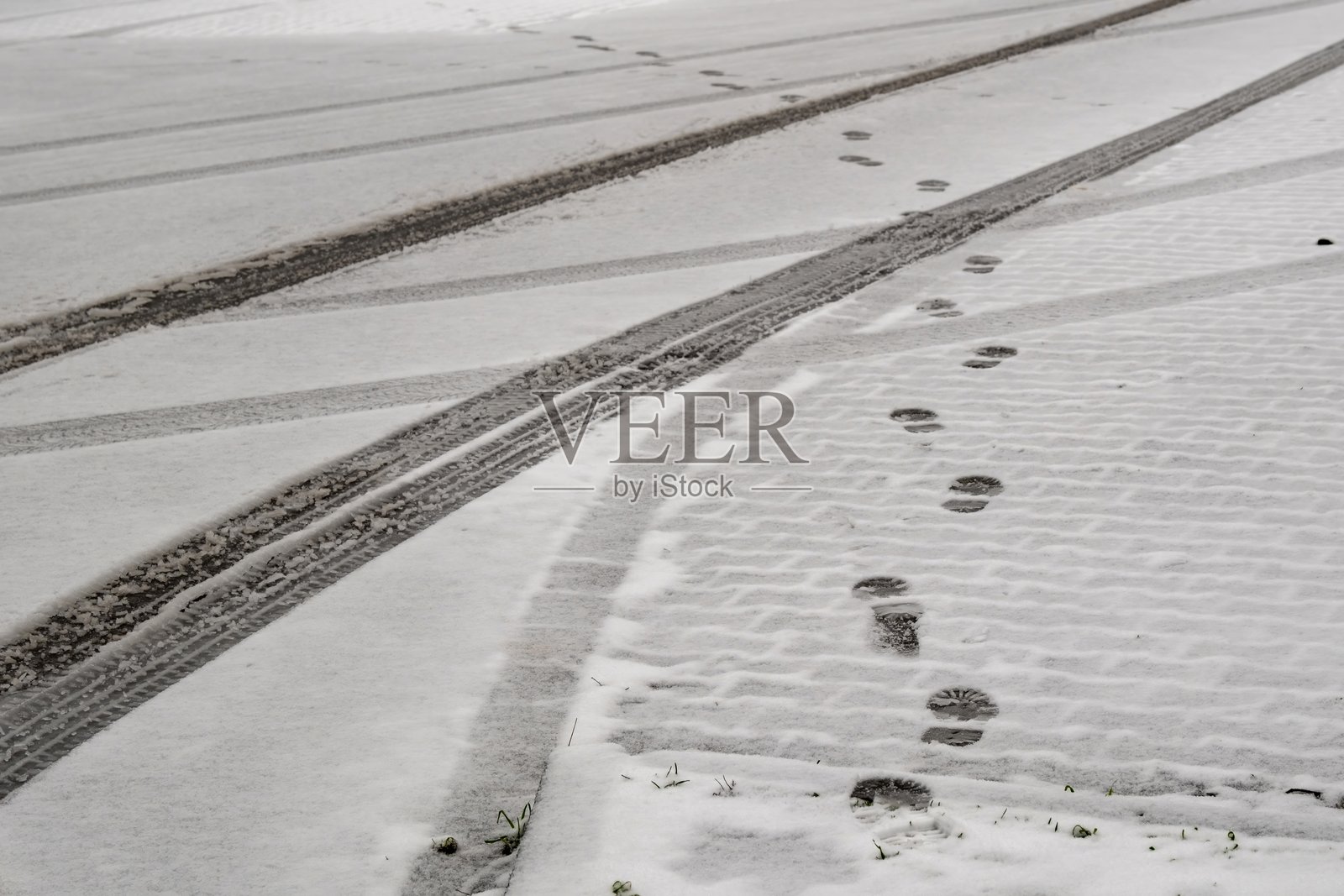 新雪表面上交错的脚印和轮胎痕迹照片摄影图片