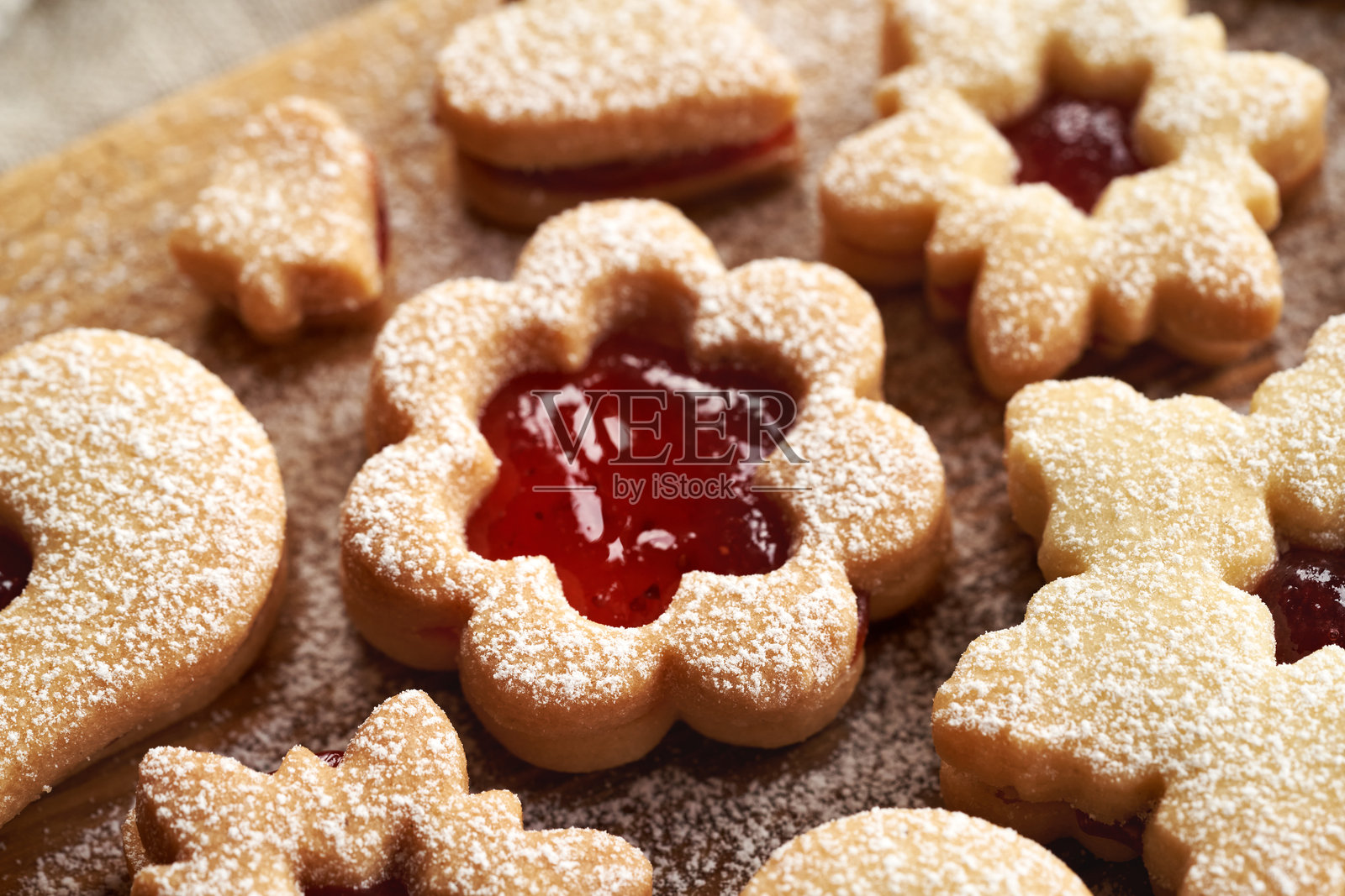 花形林泽饼干,夹有红色草莓果酱,表面撒上糖粉照片摄影图片