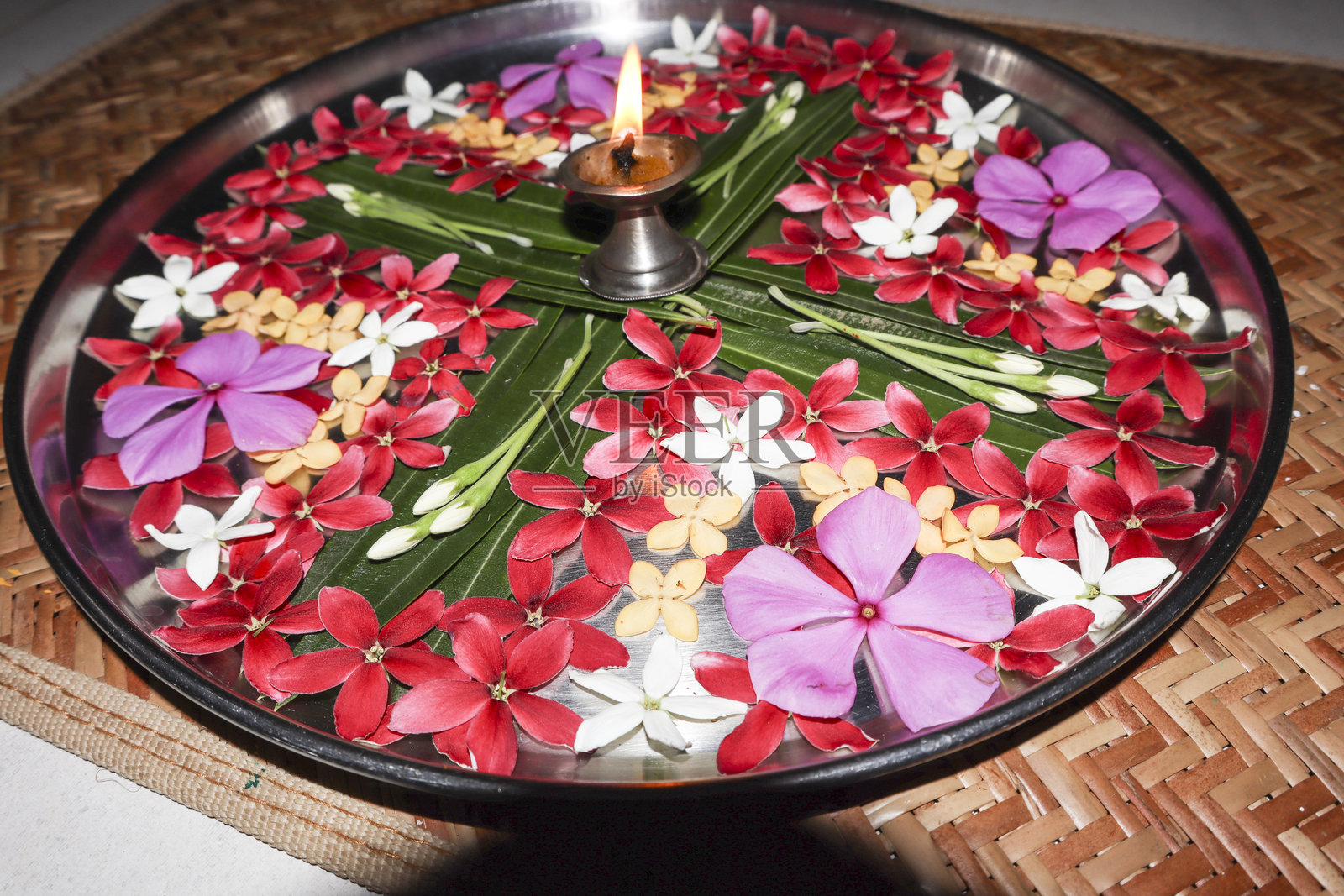 装饰有新鲜花朵的阿尔提托盘或祭祀托盘。阿尔提托盘祭祀托盘上有酥油灯。照片摄影图片