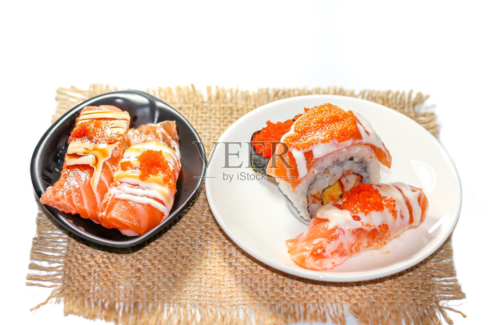 白色背景上盛放三文鱼寿司的盘子,呈现日本美食摄影风格。照片摄影图片