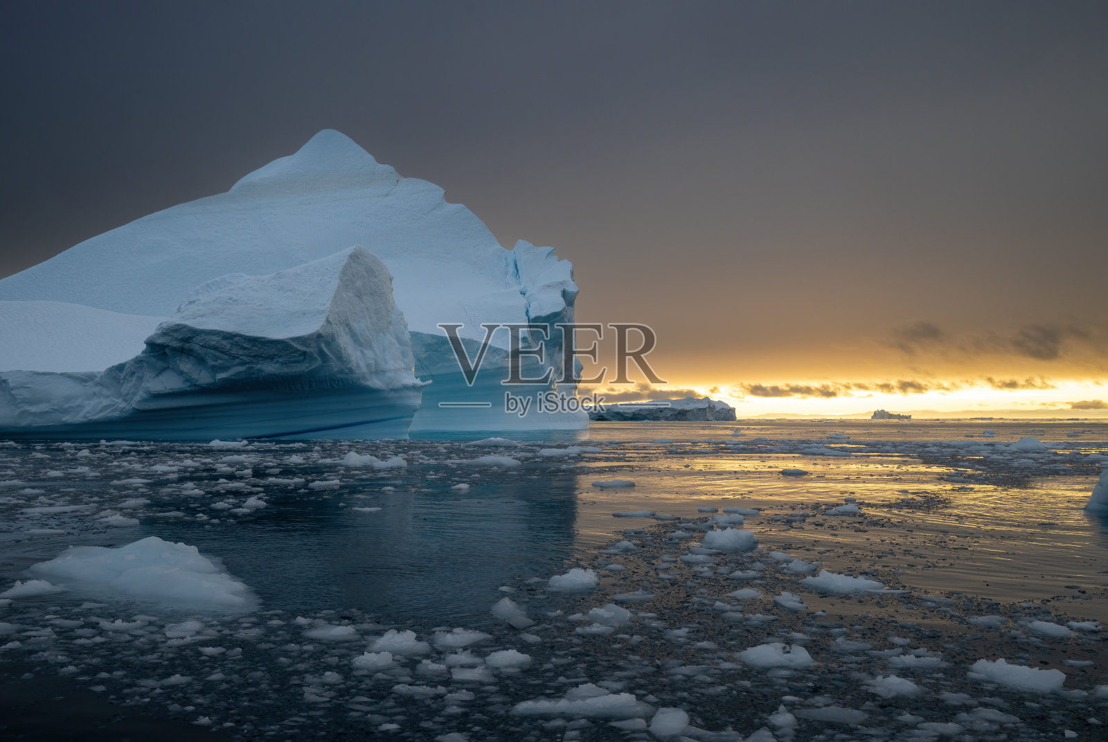 格林兰伊卢利萨特的迪斯科湾,蓝色冰山与美丽的橙色日落交相辉映的风景照片摄影图片