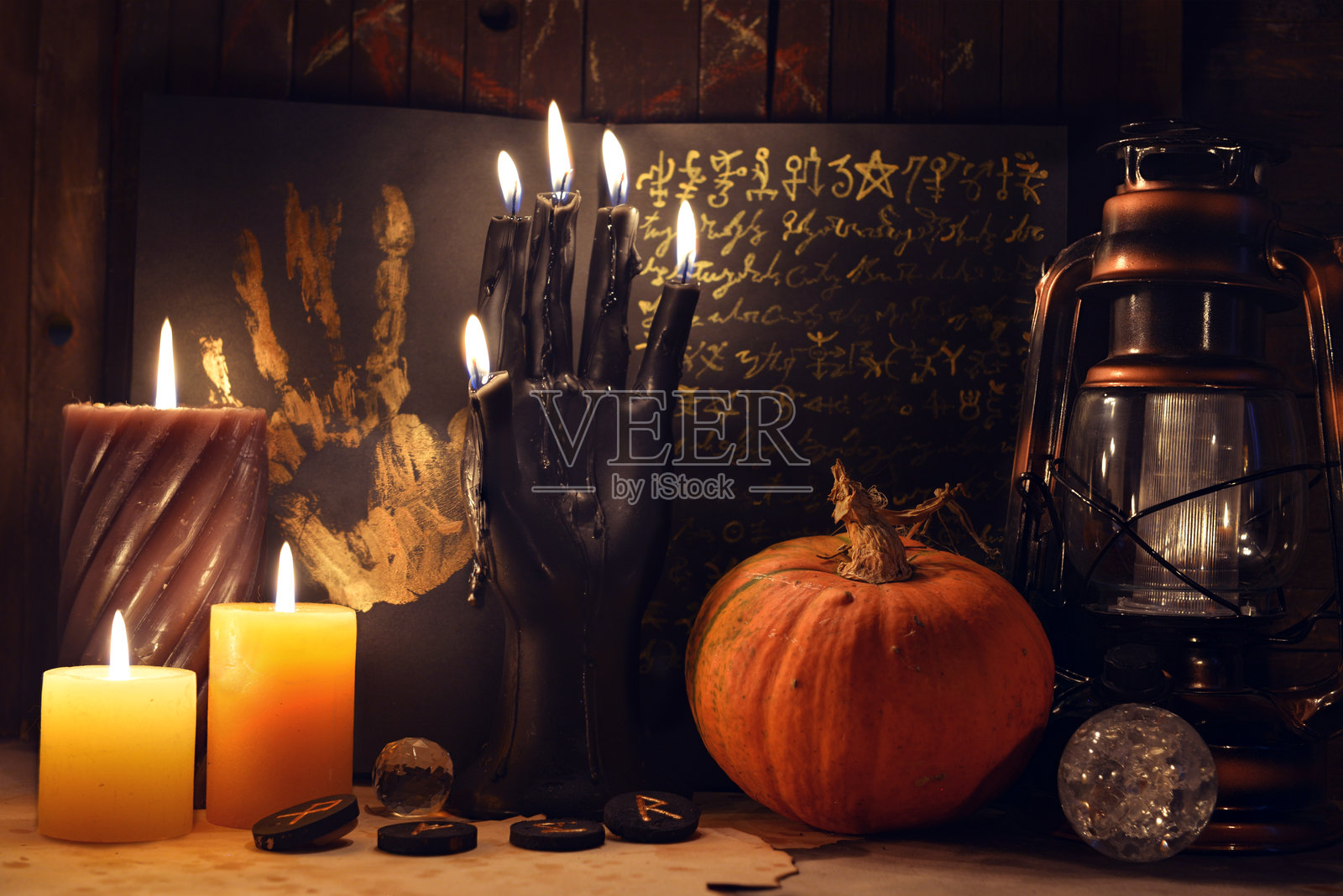 神秘的静物画,包含南瓜、黑色蜡烛、魔法咒语书、符文和巫术仪式物品。与神秘学、深奥学、万圣节和哥特风格相关的概念。照片摄影图片