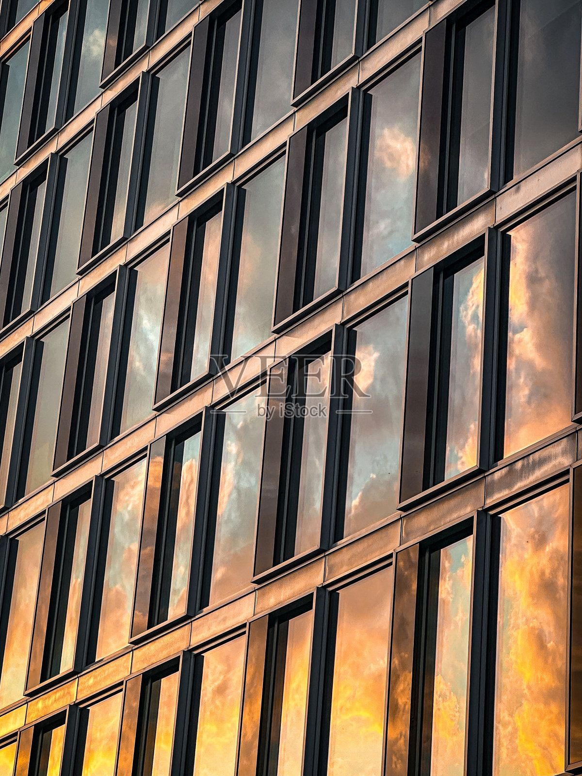 现代玻璃外立面上的日落倒影照片摄影图片