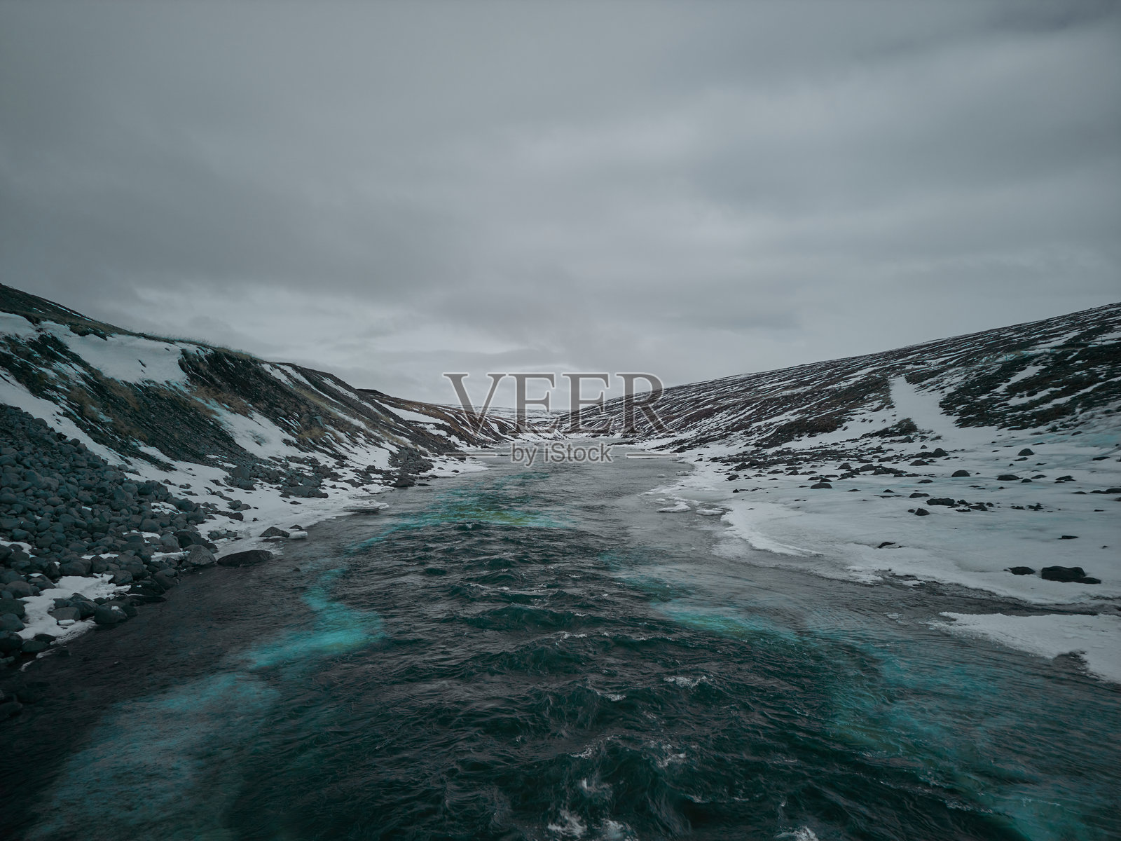 冰岛雪山景观中流淌的绿松石色河流照片摄影图片