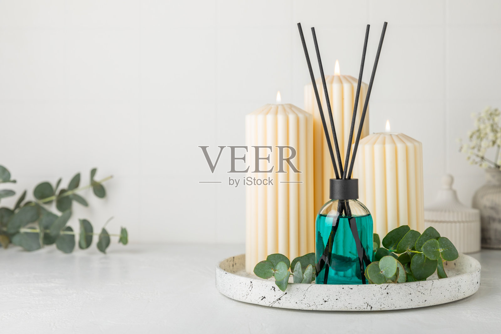 木桌上的芳香藤条空气清新剂。具有天然水果、花香和香料香气的扩散器。室内香氛。奢华的家用香水。橙子、青柠、咖啡、肉桂、八角、香草和兰花。照片摄影图片