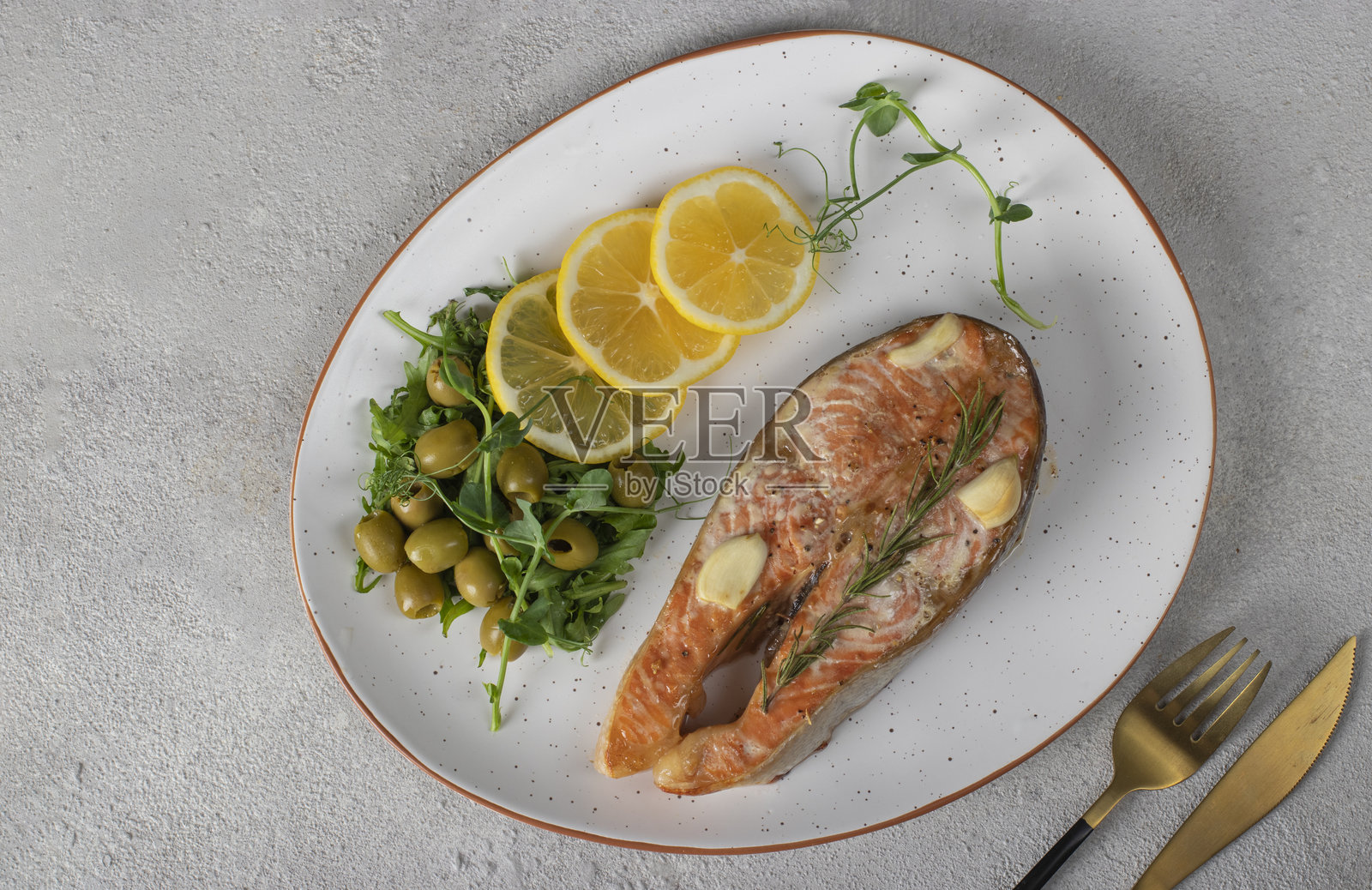 烤鳟鱼排配柠檬、迷迭香和大蒜照片摄影图片