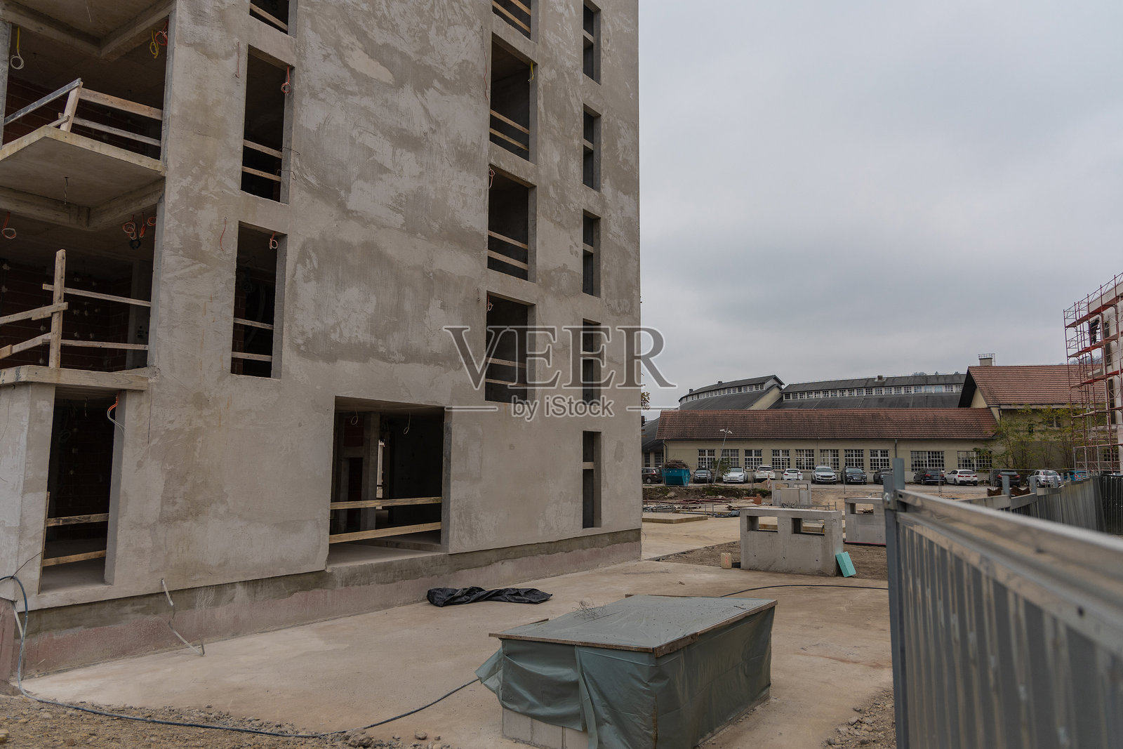 城市街区正在建设中。现代住宅的典型建筑工地,由混凝土和红砖构成。多个房屋可见。照片摄影图片