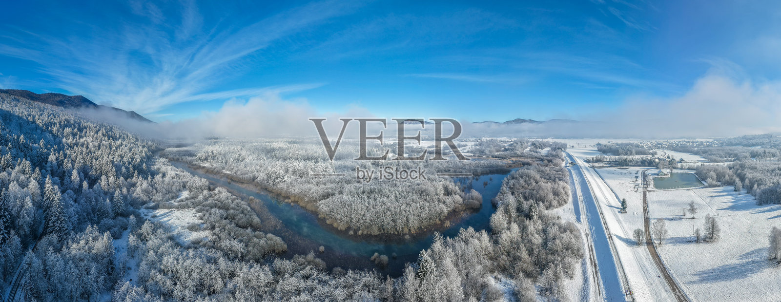 冬季航拍的里布尼察河被雪覆盖的森林环绕照片摄影图片