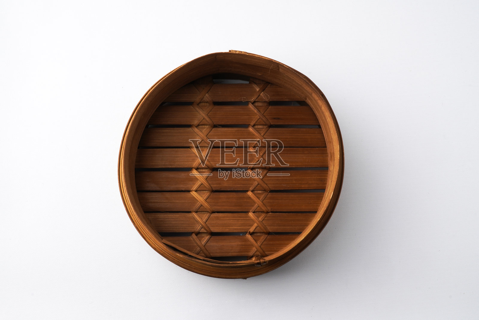 白色背景上孤立的木制点心蒸笼特写照片。拍摄角度为30度平视。照片摄影图片