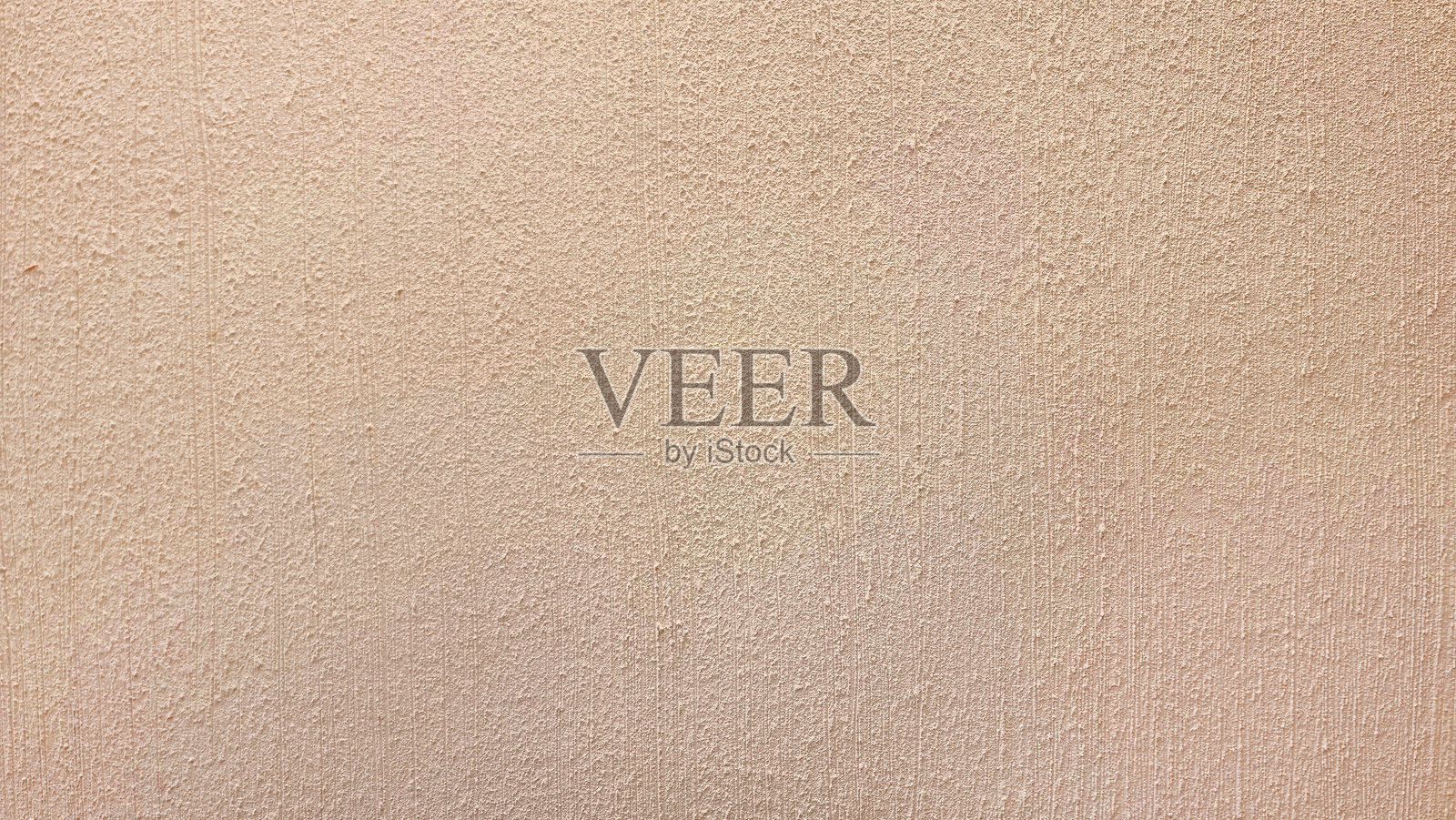 浅米色墙壁的特写,带有细腻的纹理,营造出温暖而宜人的氛围,背景为略显粗糙的棕色。照片摄影图片