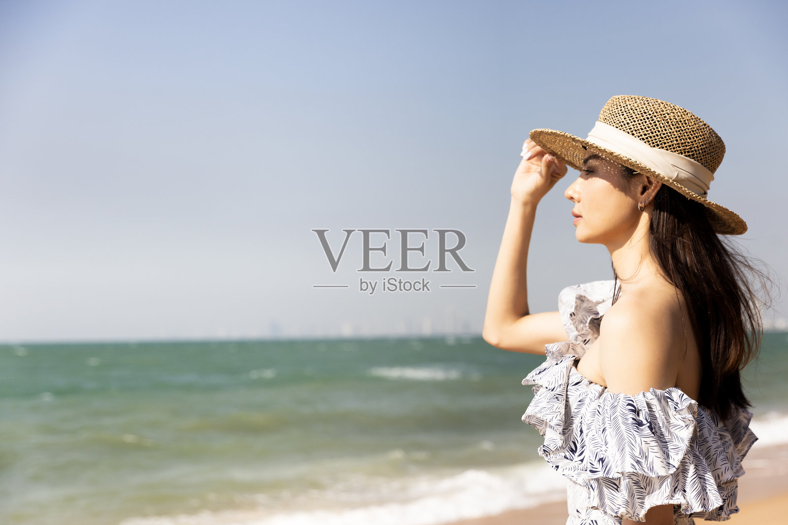 一位美丽的亚洲女性在热带海滩上放松,享受夏季假期照片摄影图片