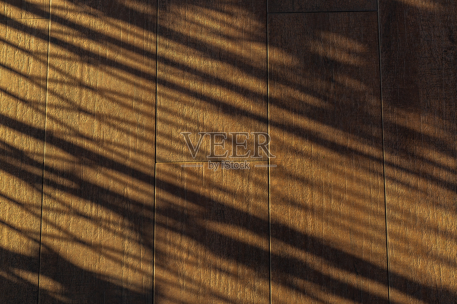 阳光影子的木地板背景,俯视柔和棕色桌子的高分辨率纹理和棕榈叶的阴影,夏季桌面背景,留有空白空间供文本或设计使用,柔和舒适的阳光桌面背景,无缝木纹。照片摄影图片