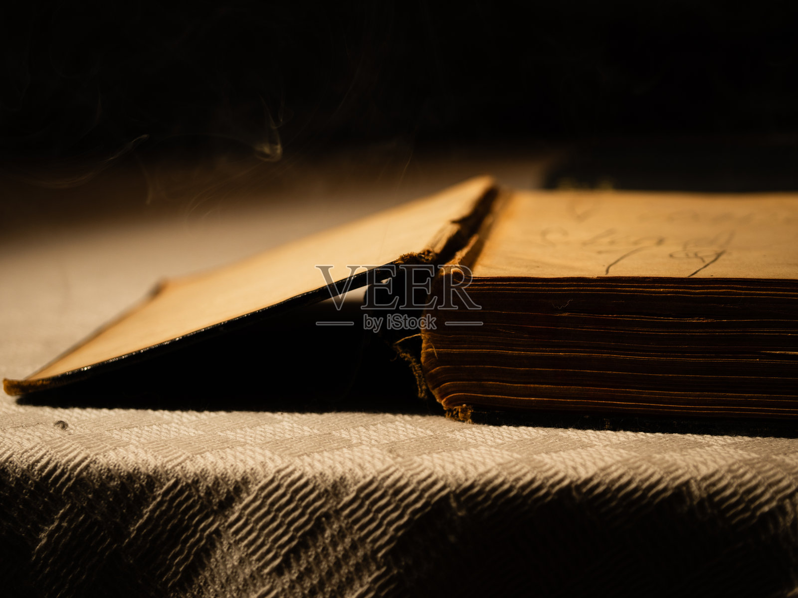 翻开的旧书与烟雾照片摄影图片