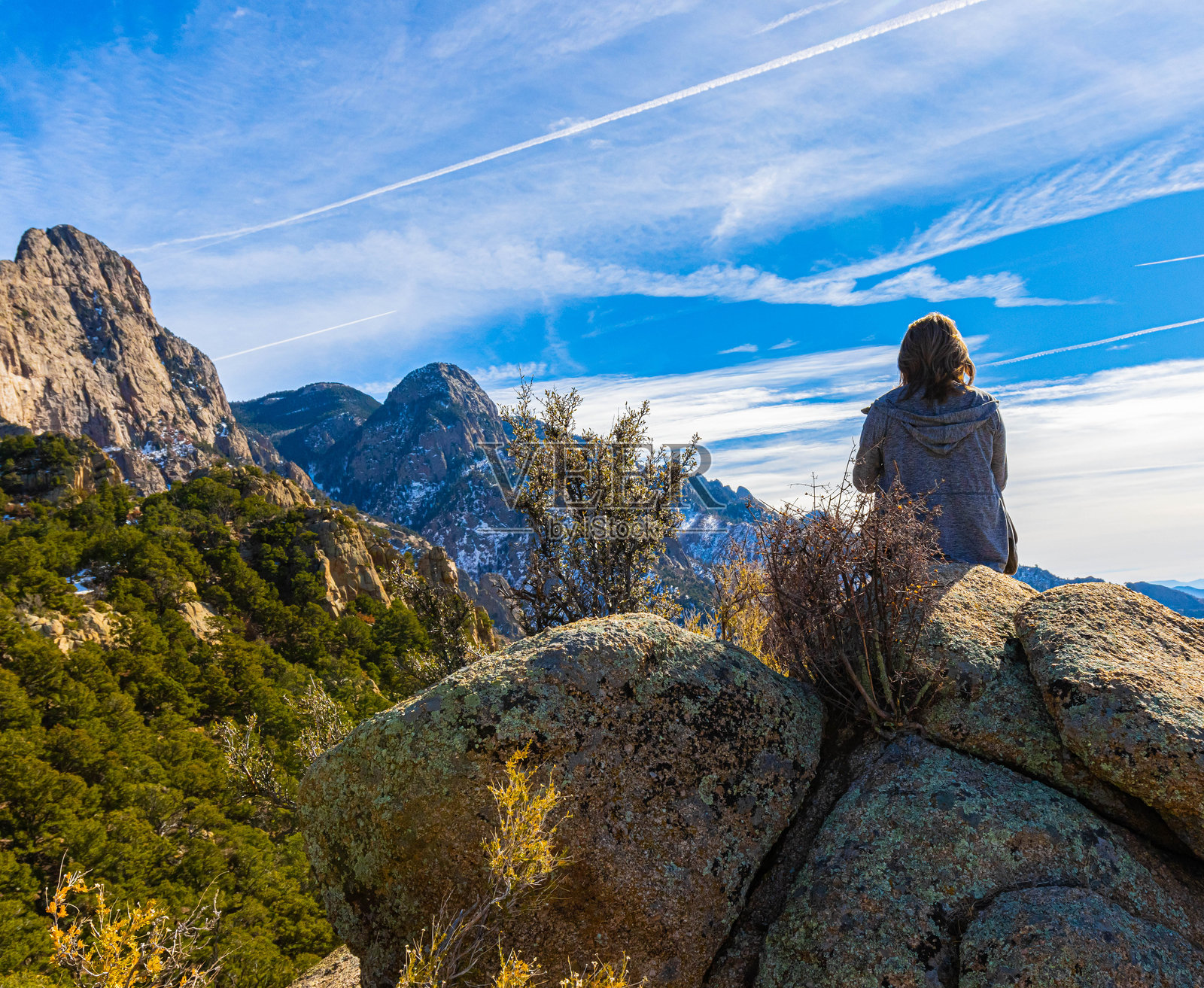 女性登山者在埃尔林孔峰的岩石突出部上照片摄影图片