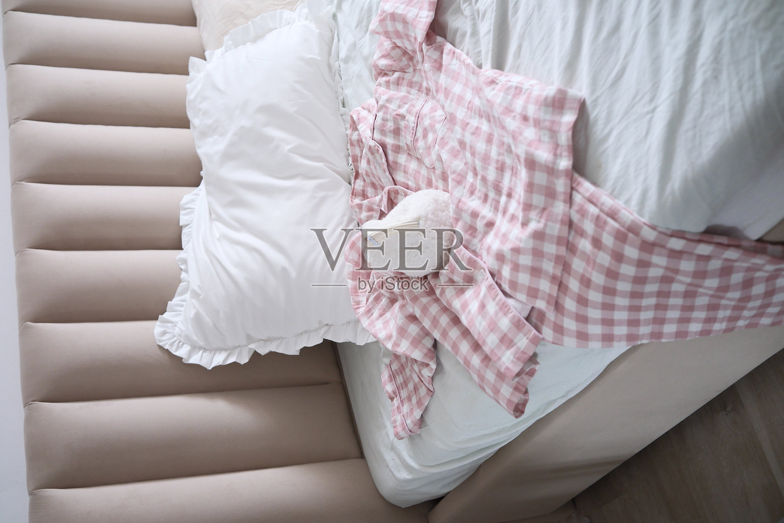 一个美丽宁静的卧室场景,展示了皱褶的床上用品和柔软的靠枕,睡衣完美适合极致放松。照片摄影图片