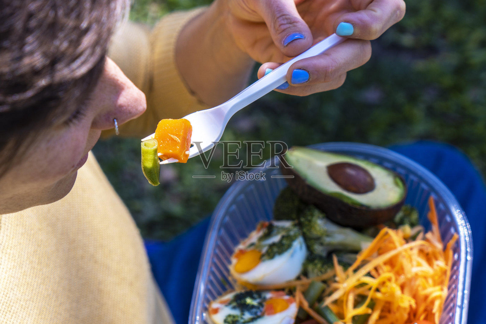 女人在户外享用新鲜的牛油果沙拉和煮鸡蛋照片摄影图片