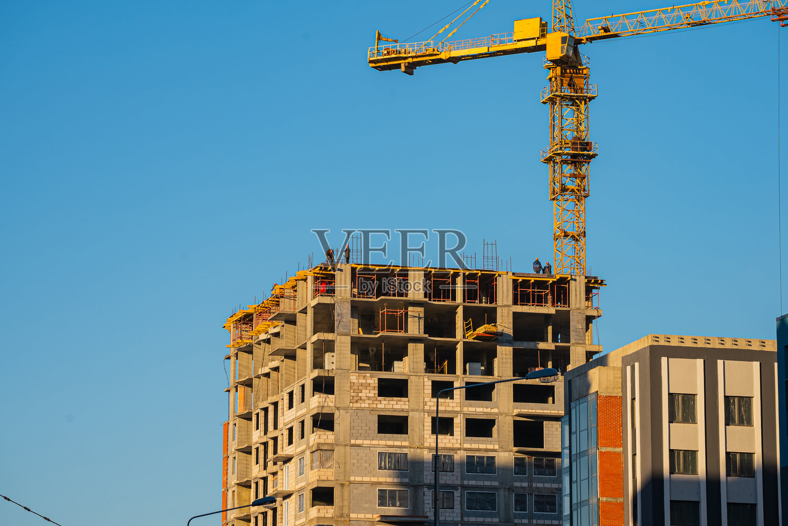 建筑工人在使用起重机建造新的公寓住宅楼照片摄影图片