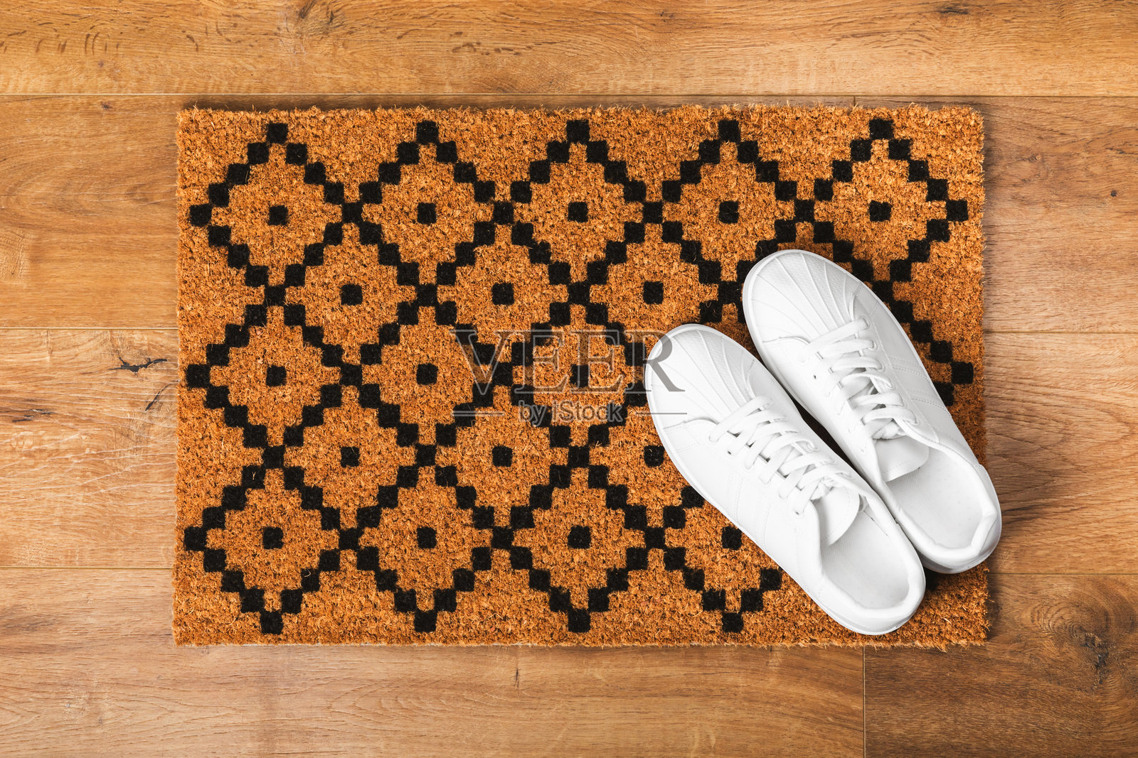 门垫。地板上的欢迎垫。女性鞋子放在门垫上,背景为室内装饰元素。特写。留白空间。走廊门口的地毯。照片摄影图片