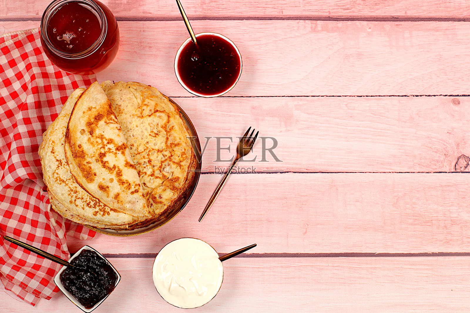 美味的俄罗斯煎饼配果酱、软奶酪和蜂蜜,摆放在大理石桌上。健康的早餐,体现天然产品和传统民族美食的概念,面包店的广告。照片摄影图片