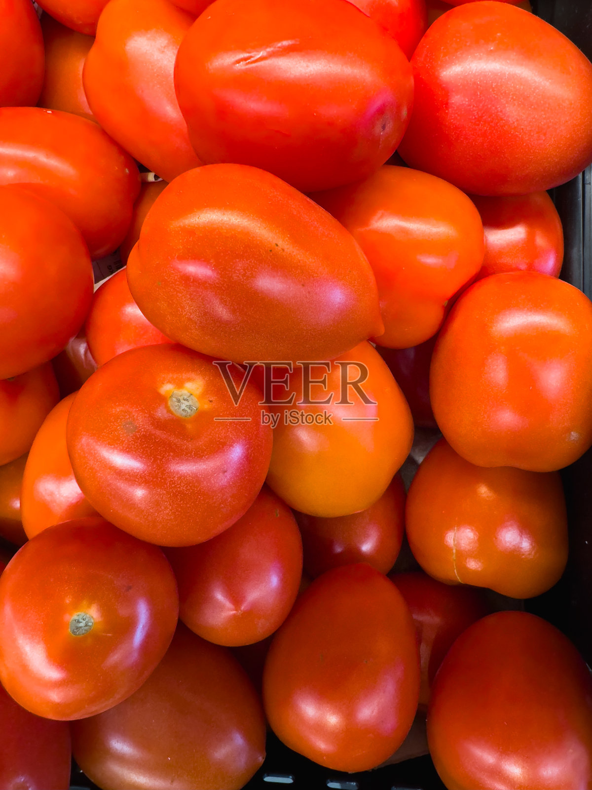 鲜红的番茄整齐地放在容器中,特写视角。照片摄影图片