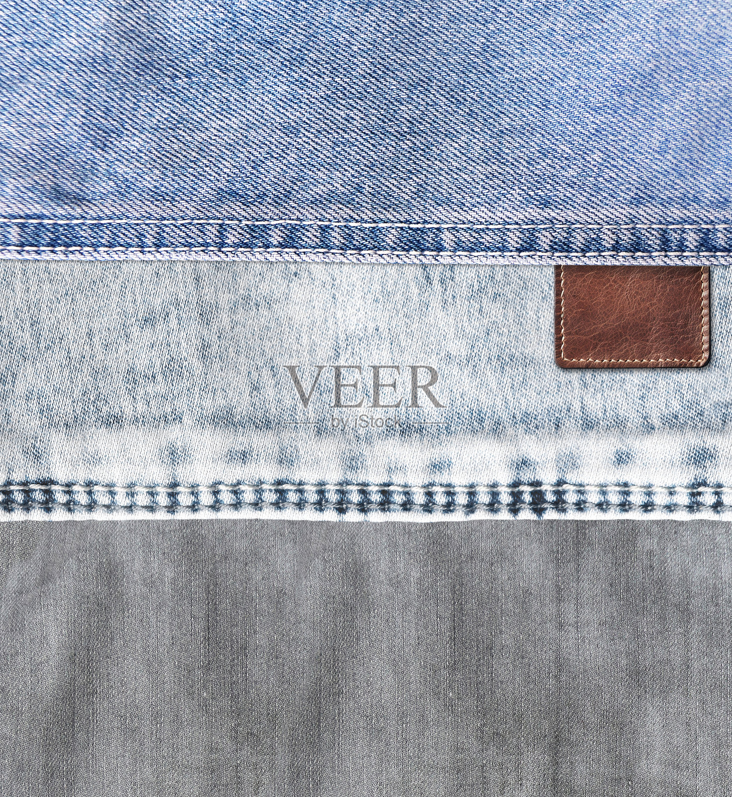 蓝色和灰色牛仔布纹理的垂直背景,带有缝线和旧皮革标签。蓝色和灰色的牛仔材料以及棕色的复古标签。模版设计。文本留白空间。照片摄影图片