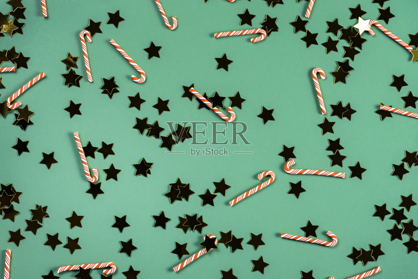 绿色背景上的圣诞背景,装饰有糖果手杖和星星。照片摄影图片