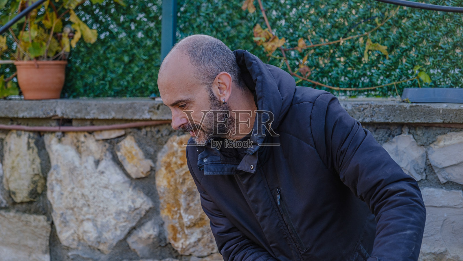 一个中年男子在冬天的日子里用割草机在花园里修剪草坪照片摄影图片