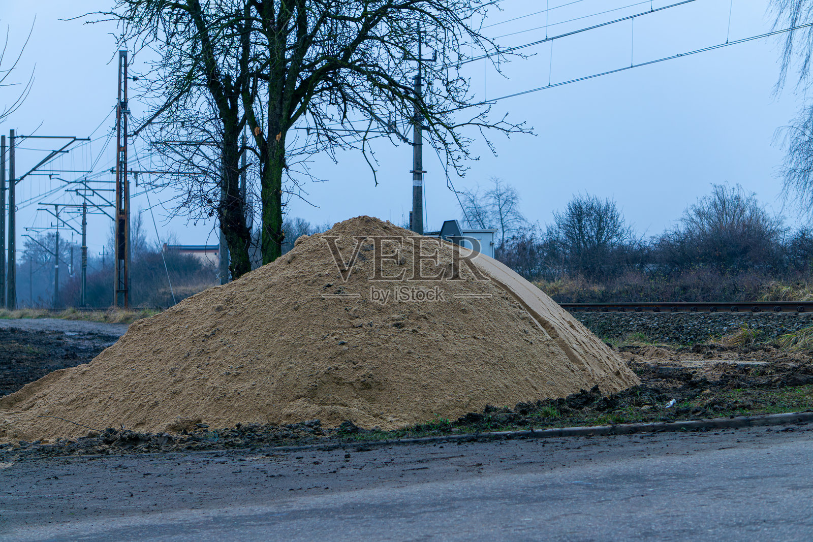 一堆沙子躺在轨道和铁路基础设施旁边照片摄影图片