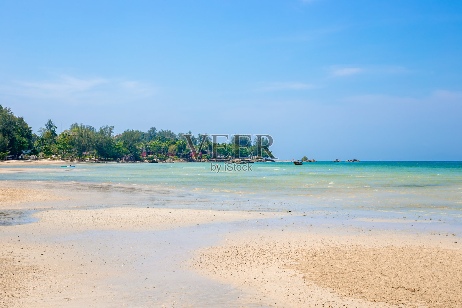 热带海岸,沙滩和低潮。地平线上有小屋和船只。照片摄影图片