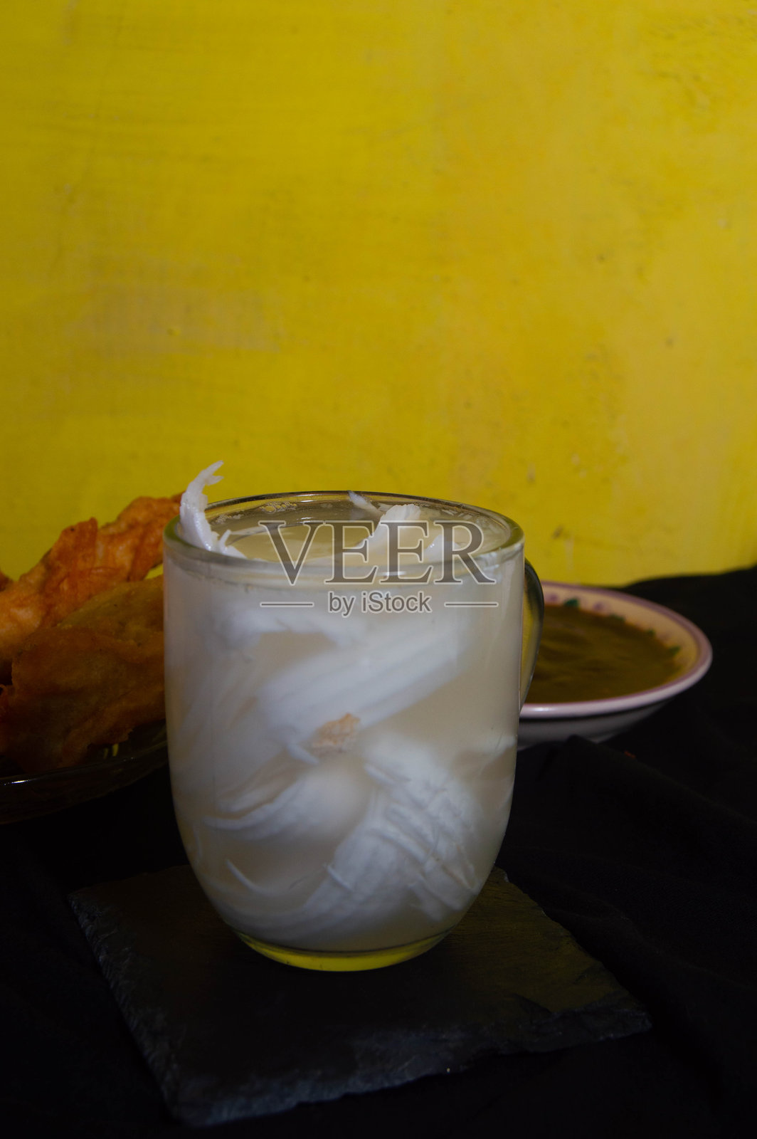 黑色背景下的年轻椰子冰饮在玻璃杯中照片摄影图片