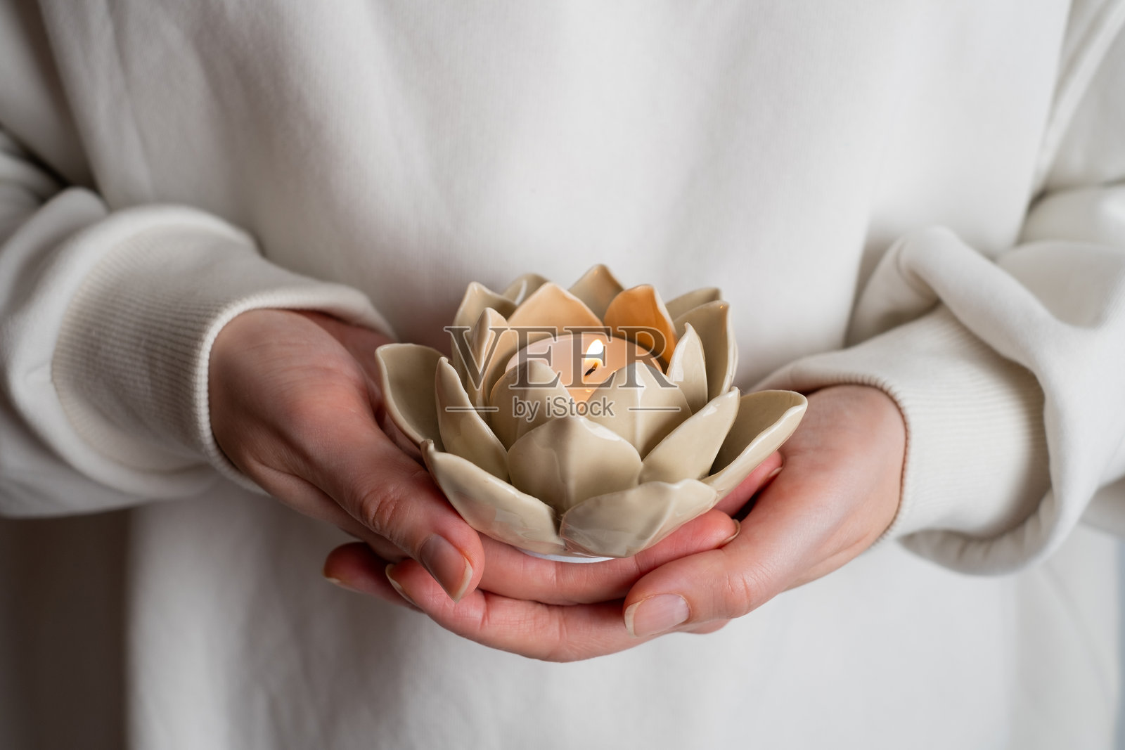 女人手中燃烧的莲花形蜡烛。和谐的概念照片摄影图片