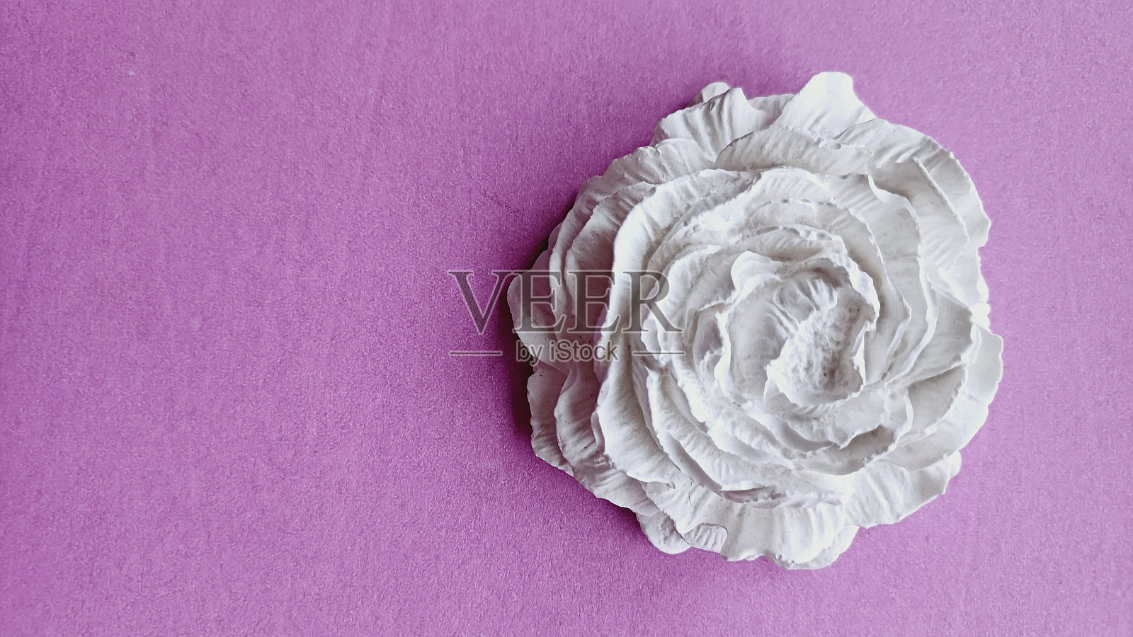 粉色背景上的白色陶瓷装饰花照片摄影图片